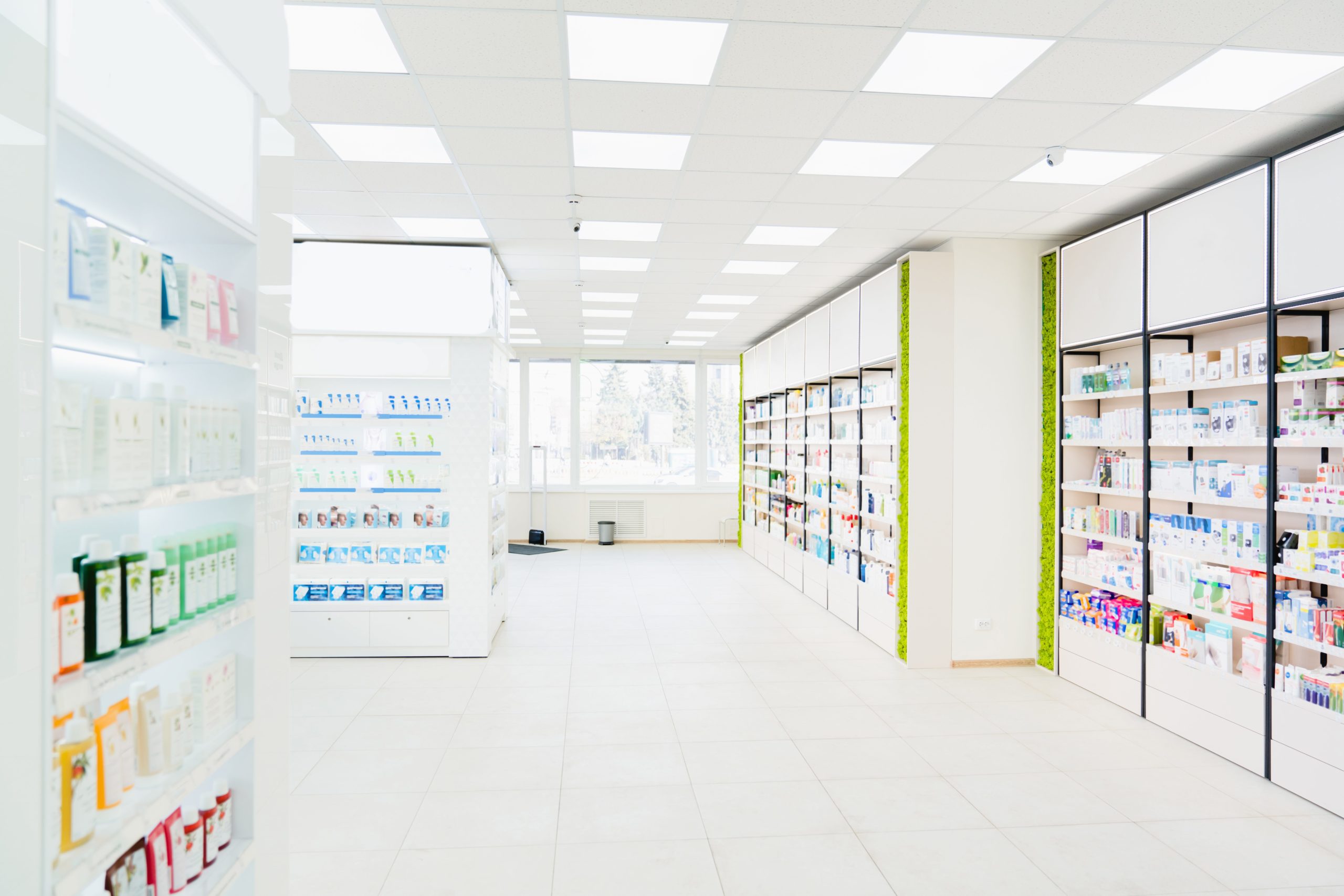 Spacious modern new white drugstore pharmacy chemist`s store with shelves full of medicines, pills